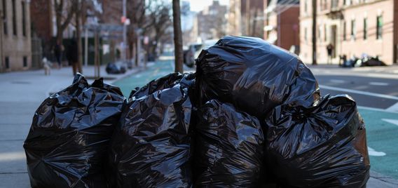 Black trash bags on a sidewalk in New York City